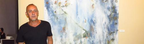 Jesús Mozos junto a una de sus obras en el Certamen de Pintura 2017 de Manzanares