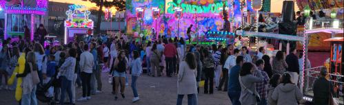 Zona de atracciones de las fiestas el domingo al atardecer